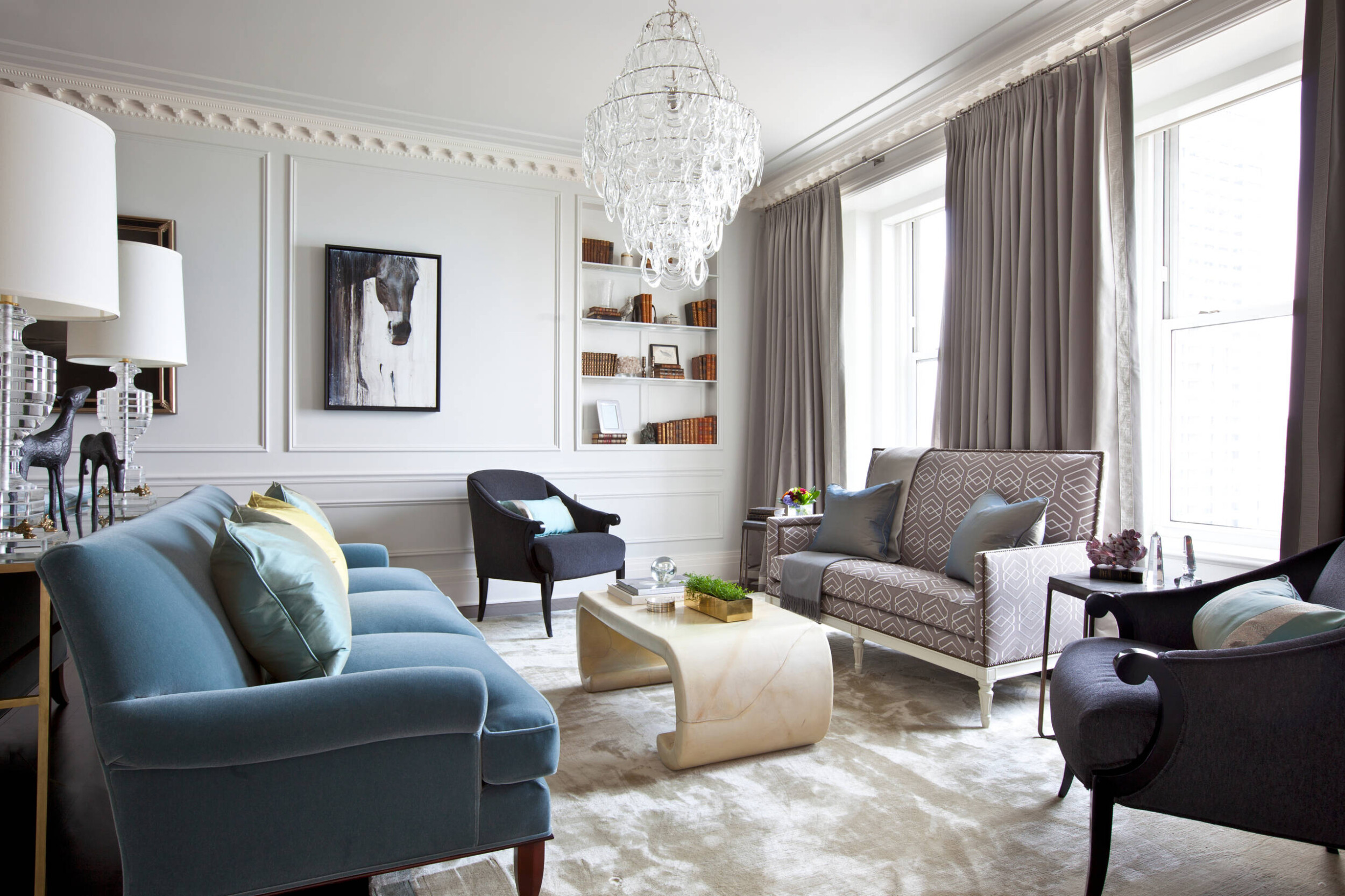 Phong cách thiết kế nội thất chuyển tiếp: phòng khách có sofa xanh, đèn chùm pha lê