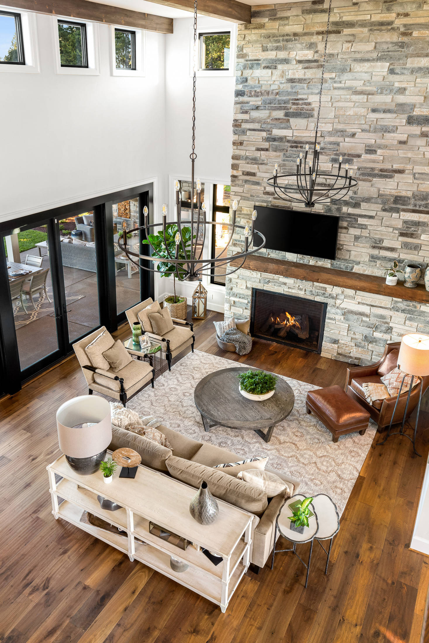 Modern living space with high ceilings and large stone fireplace 